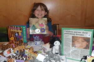 Ein kleines Mädchen hält eine Keksdose in der Hand und steht vor Spielzeug und Büchern.