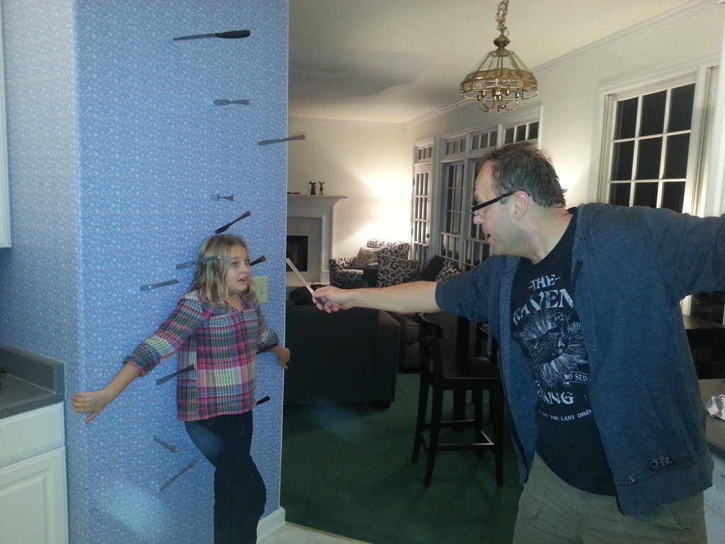 Eine Gruppe von Menschen, die mit einem Mann stehen, der ein Messer hält.