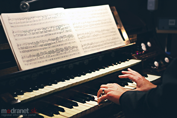 Eine Person, die eine Piano-Tastatur spielt, mit einem Buch auf dem Piano.