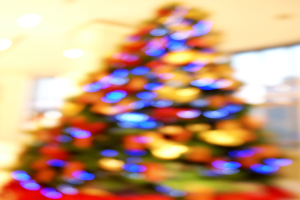 Ein unscharfer Schnappschuss eines drinnen geschmückten Weihnachtsbaums.