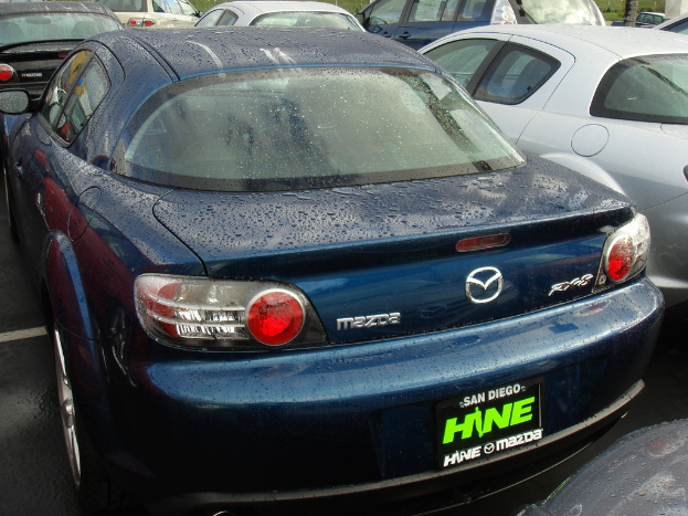 Mehrere Autos stehen auf einem Parkplatz mit einem Schild am Boden mit Text.