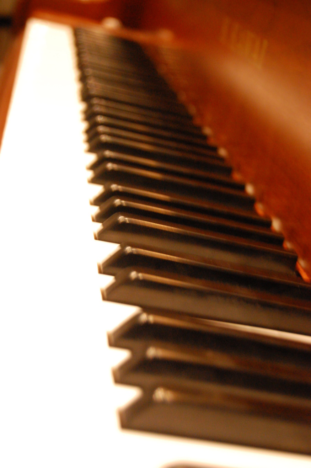 Ein schwarzer Klavierflügel mit geschlossenem Deckel und einem Notenständer.