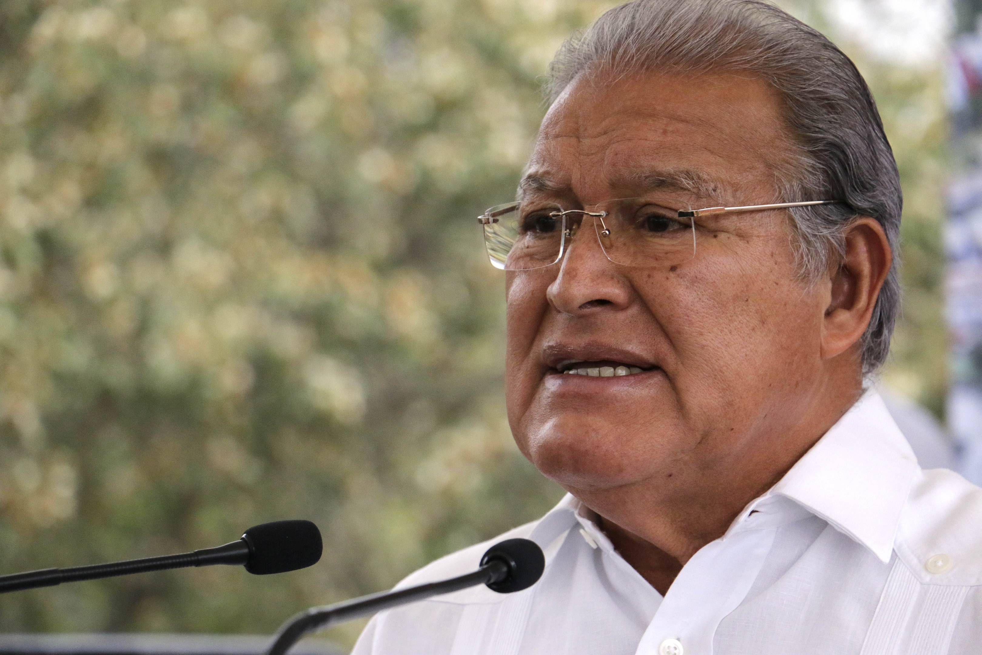A man in a white shirt and glasses speaks into a microphone, likely responding to a Supreme Court decision regarding the Supreme Judicial Court of India.