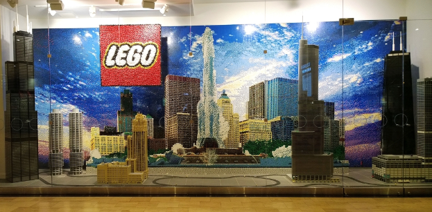 Lego-Kunstwerke auf einem Boden mit einer Wand im Hintergrund.