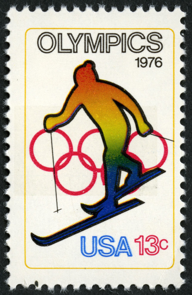 Schwarzer Poststempel mit olympischem Logo und einem Skispringer, mit schwarzem Text.