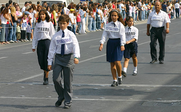 Eine Gruppe von Menschen, die auf einer Stra√üe gehen, mit Abzeichen auf ihren Hemden, umgeben von einer gro√üen Menge.