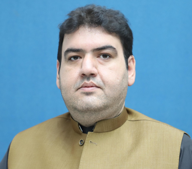 Ein Mann in einem braunen Hemd und schwarzer Weste steht vor einem blauen Hintergrund und sieht bedrückt und verzweifelt aus, wahrscheinlich wegen einer lebenslangen Haftstrafe.