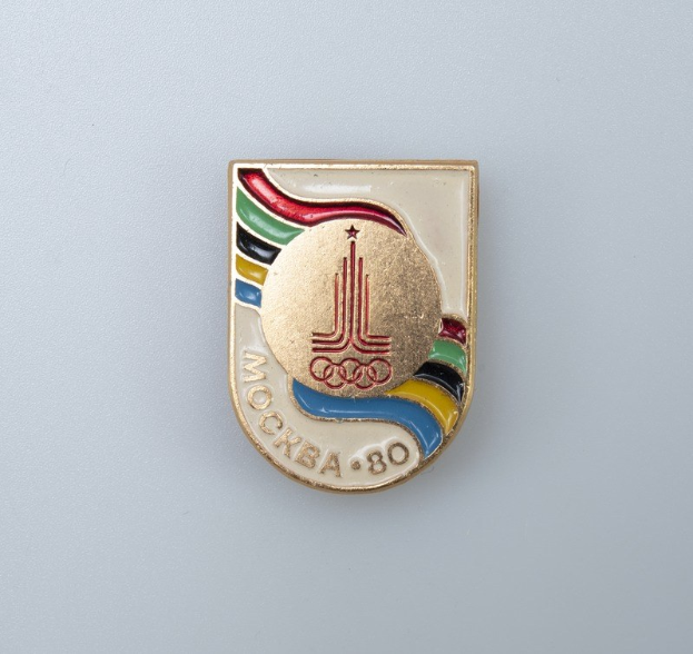 Eine weiße Oberfläche mit einem Abzeichen, das das Emblem und den Text der Olympischen Winterspiele 1980 in Moskau, Russland, zeigt.