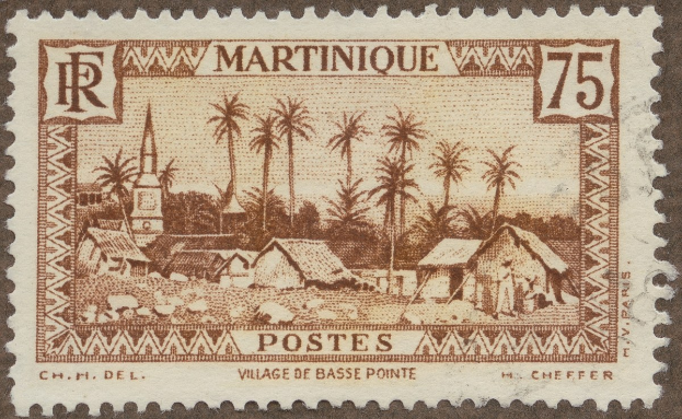 Postage stamp depicting a village with huts and palm trees, including printed text.