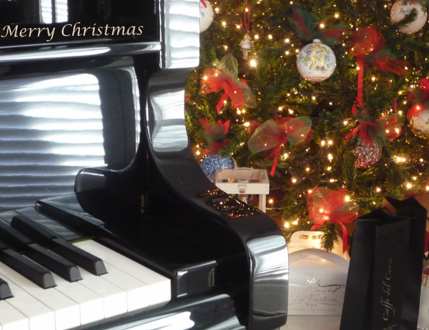 Ein Weihnachtsbaum und ein Piano sind auf dem Boden platziert, mit verschiedenen Gegenständen, die am Baum hängen.