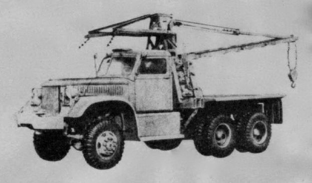 Schwarz-weiß-Foto eines großen, vierrädrigen Lastwagen mit einem Kran auf dem Rücken und einem flachen Anhänger, der angeblich das erste Schwerlastfahrzeug der Welt ist.