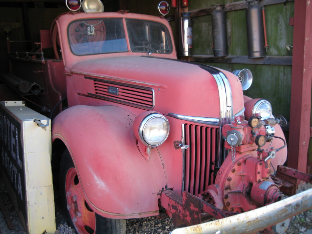 Ein Kraftfahrzeug steht auf einem steinbedeckten Boden mit Feuerlöschern, die an der Wand neben ihm montiert sind.