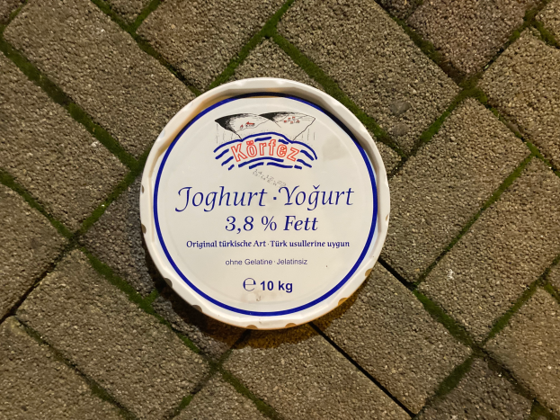 Ein Teller Joghurt mit Text darauf, auf einem Ziegelsteinweg platziert.