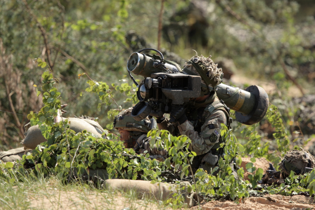 Zwei Soldaten vor grünen Pflanzen und Bäumen