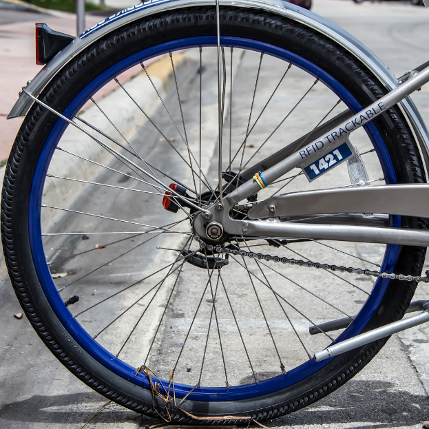 Ein graues Fahrrad mit blauen Speichen.