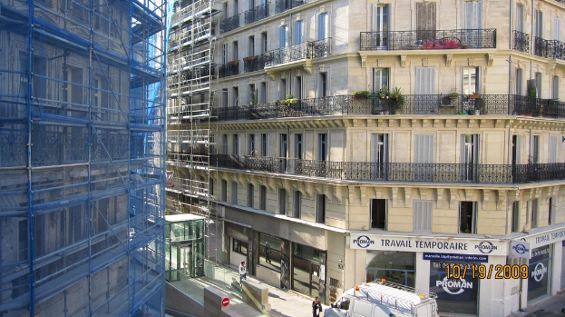 Ein großes Gebäude in Bau auf der linken Seite, mit einem Geschäft auf der rechten Seite unten.