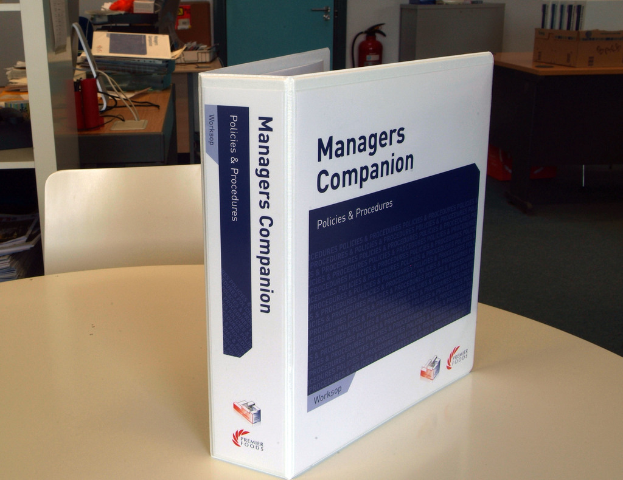 Ein Buch auf einem Tisch mit einem Stuhl dahinter, in der N├Ąhe einer T├╝r, Feuerl├Âscher, Dateien und andere Gegenst├Ąnde.