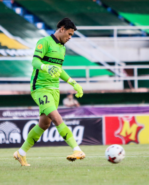 Ein Mann in einem grünen Torwarttrikot schießt einen Fußball auf einem Rasenfeld in einem Stadion. Im Hintergrund sind Banner mit 'Chivas USA vs Mexico City, 3-1, Copa Libertadores' zu sehen.