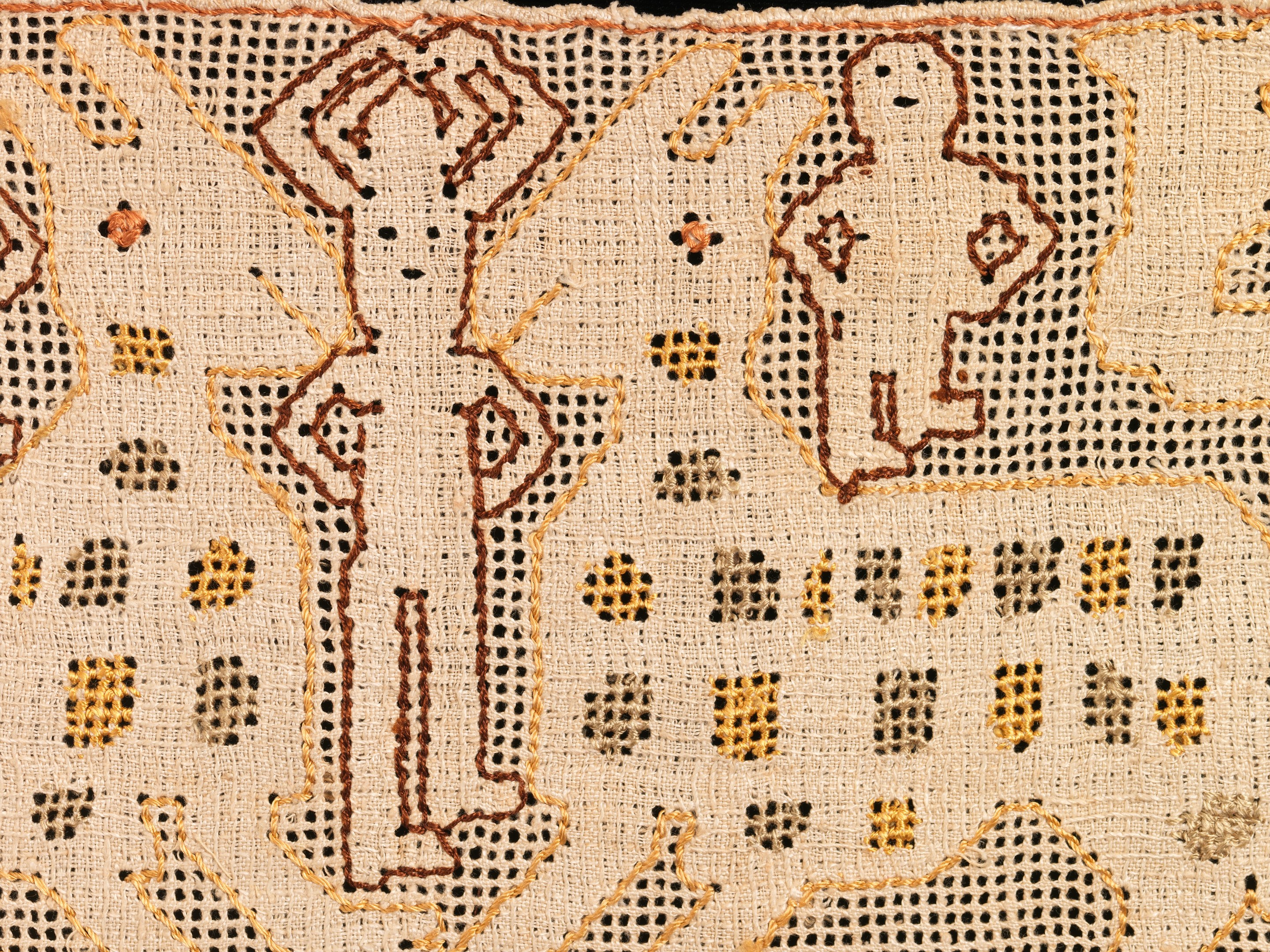 Close-up of a patterned textile with various shapes and colors in an intricate design.