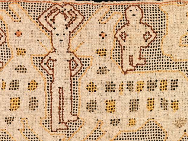 Close-up of a patterned textile with various shapes and colors in an intricate design.