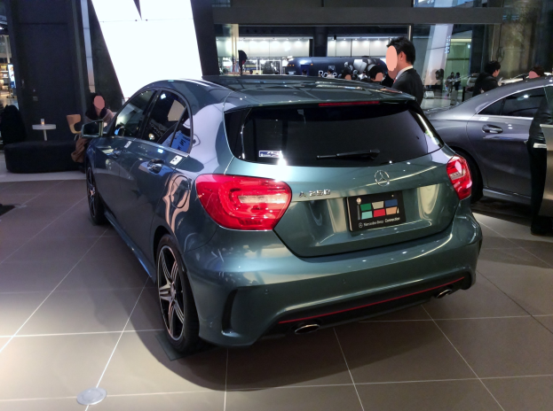 Ein Mercedes-Benz A-Klasse Hatchback auf der IAA in Frankfurt, glänzend schwarz mit Chromakzenten, niedriger Profil, breite Basis, markantes Grill und Aluminiumräder, umgeben von Menschen.
