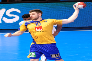 Ein Mann in gelbem T-Shirt und blauen Shorts spielt Handball auf einem Platz, hält einen Ball und hat im Hintergrund einen Bildschirm mit der Aufschrift "Svenský Spel Handball-Weltmeisterschaft 2019".