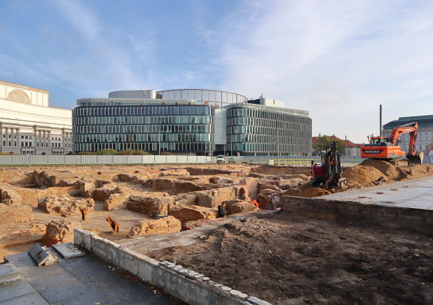 Baustelle in Berlin, Deutschland, während des Baus der Berliner Mauer, mit einem großen Gebäude, Fahrzeugen, Arbeitern, Materialien und städtischen Elementen unter einem bewölkten Himmel.