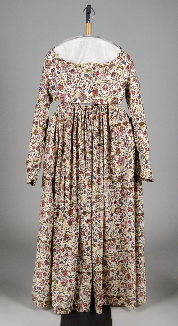 White floral-patterned dress with fitted bodice and floor-length full skirt, displayed on a hanger against a white background.