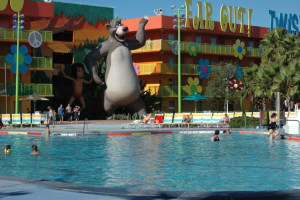 Ein Schwimmbad mit blauem Wasser und Menschen beim Schwimmen, mit entfernten Cartoons und Stangen im Hintergrund.