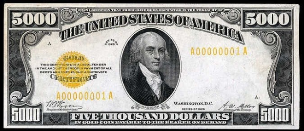 Eine US-amerikanische Fünfausenddollarnote mit einem Porträt von George Washington, auf der "United States" und "Five Thousand Dollars" in fetter Schrift auf einem schwarzen Hintergrund abgedruckt sind.
