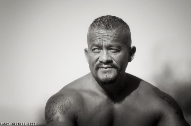 Ein Schwarz-Weiß-Bild eines Mannes, der nach links schaut, mit einem unscharfen Hintergrund und Text in der unteren linken Ecke.