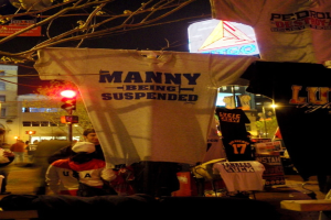 Eine Gruppe von Menschen in T-Shirts mit Hintergrund von Ampeln, Bäumen, Pfählen und Gebäuden.