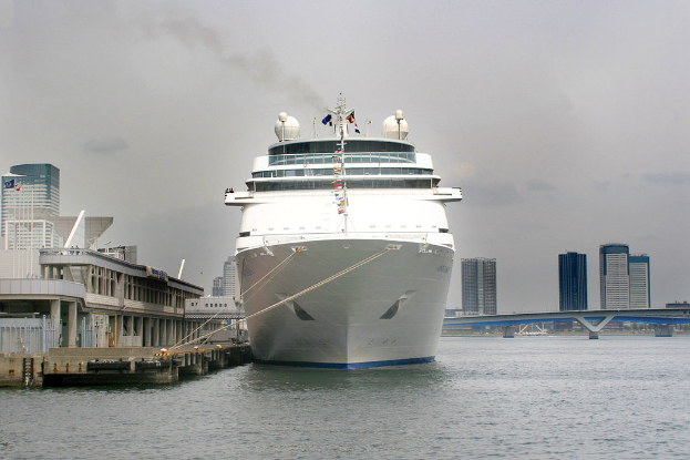 Ein Schiff schwimmt auf dem Wasser neben einer Br√ľcke und zahlreichen Geb√§uden.