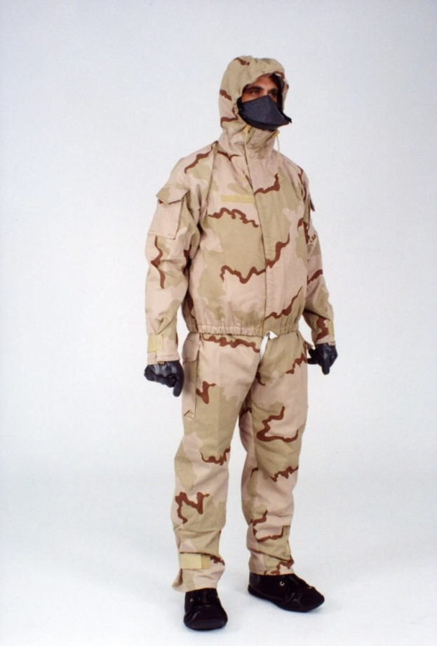 Ein Mann in einem Tarnmuster-Schutzoverall und Maske steht vor einem weißen Hintergrund, der Anzug ist für den Schutz vor gefährlichen Materialien mit einer Kapuze, verstellbaren Riemen und Reißverschluss ausgestattet.