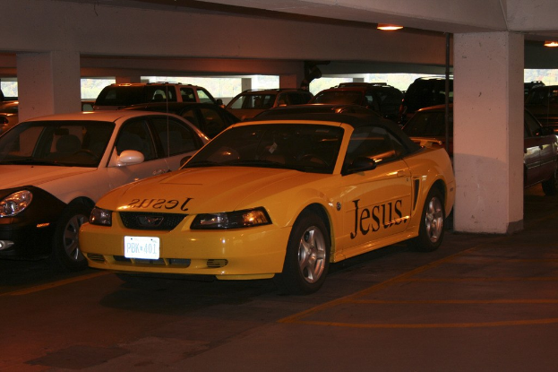 Ein überfüllter Parkplatz mit zahlreichen geparkten Autos ├Ąußerlich eines Geb├Ąudes.
