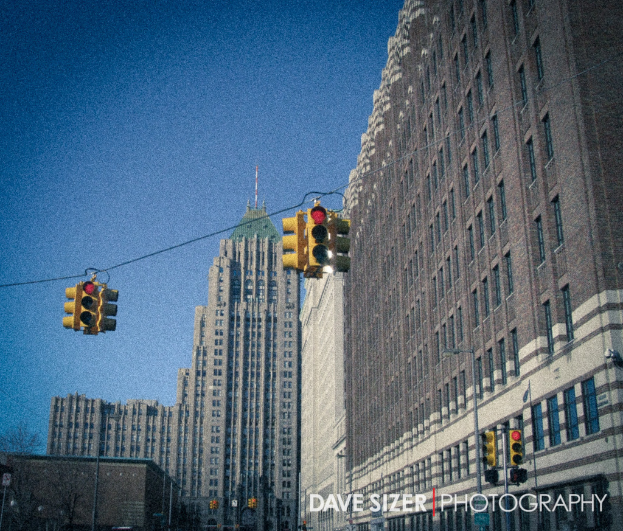Mehrere Ampeln an Pfosten vor Gebäuden angebracht.