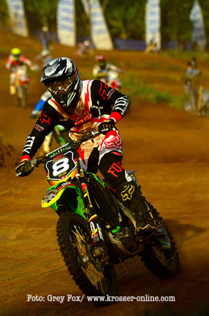 A group of motorcyclists wearing helmets racing on a track with text at the bottom.